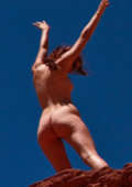 young girl posing naked on a big rock