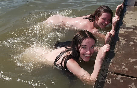 two juicy nudist girls having fun in the water